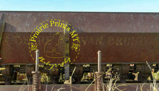 old farm equipment sitting in a field under a blue sky